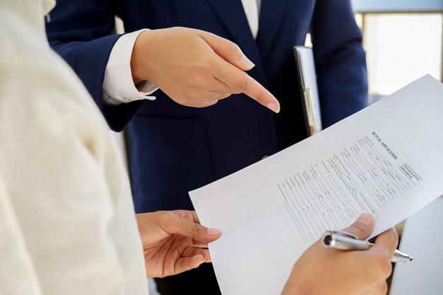 man_in_a_suit_pointing_at_some_documents 