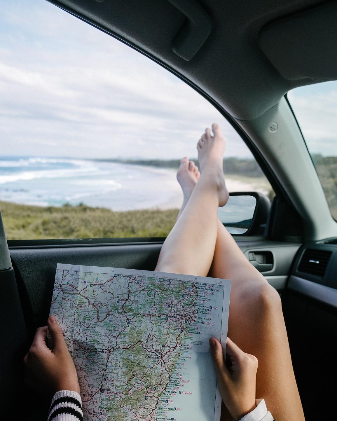 woman_reading_a_book_with_her_legs_sticking_out_a_car_window