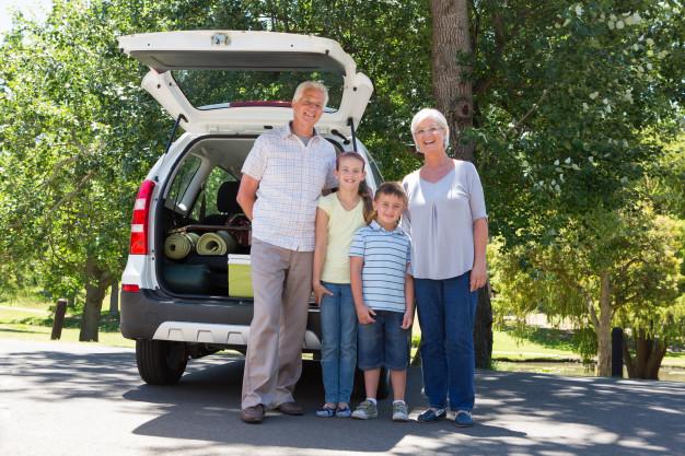 family_standing_infront_of_the_back_of_an_SUV_with_an_open_boot