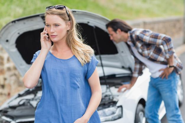 a_woman_on_the_phone_whilst_a_man_looks_at_the_engine