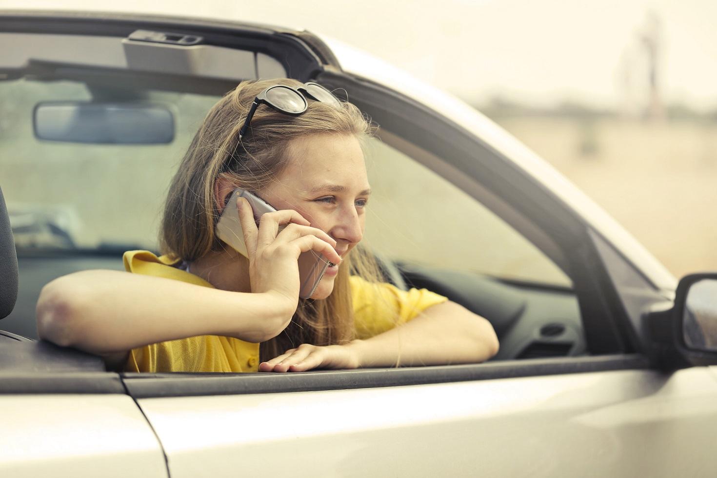 blonde_haired_woman_talking_over_the_phone_in_a_stationary_car