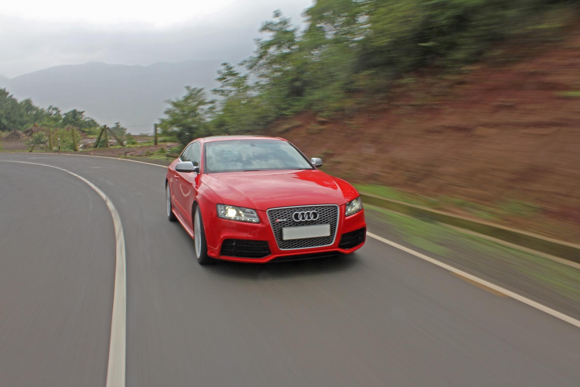 A red Audi driving along a road