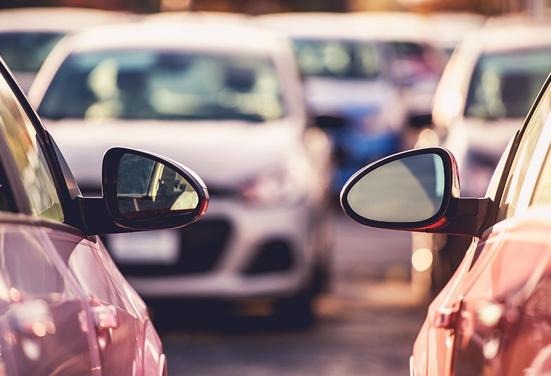 Electric car depreciation two red car wingmirrors side by side