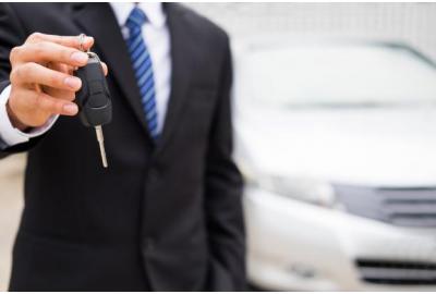 man_in_a_suit_holding_out_car_keys
