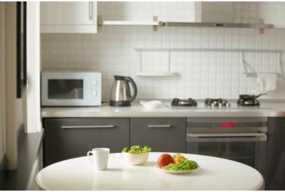 a_small_kitchen_white_tiled_and_grey_cupboards