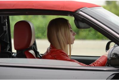 side_profile_of_a_young_woman_driving_a_red_car