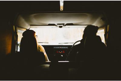 silhouette_of_the_back_of_two_people_driving_a_van 