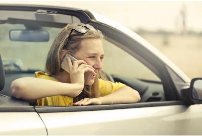blonde_haired_woman_talking_over_the_phone_in_a_stationary_car