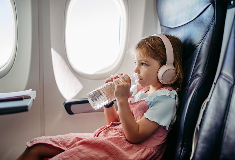 family travel tips - little girl in airplane
