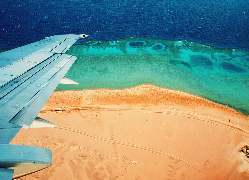 holiday plane wing travelling over the sea