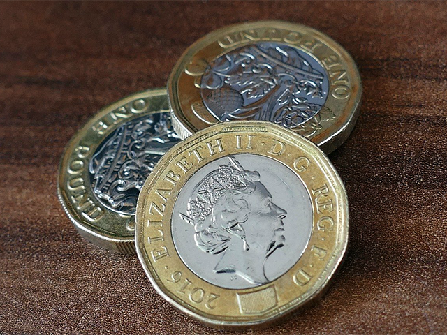 pound_coins_on_a_wood_surface