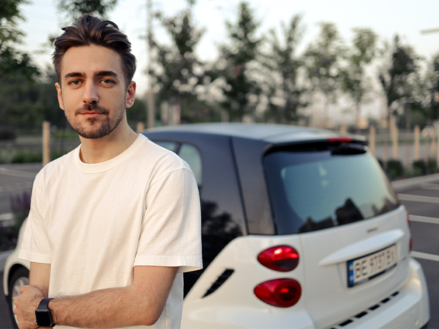 young_driver_standing_next_to_a_car