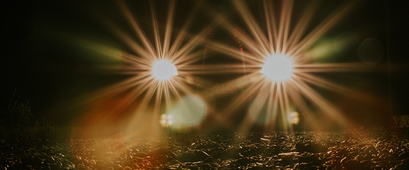 car headlights lighting up road at night