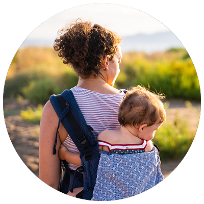 family travel tips - mom carrying a baby on her back in a baby carrier