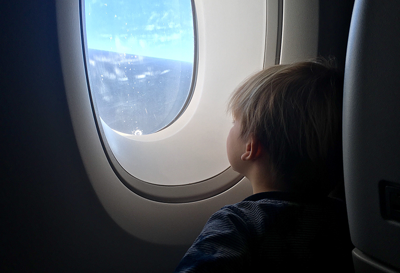 family travel tips - toddler looking out airplane window